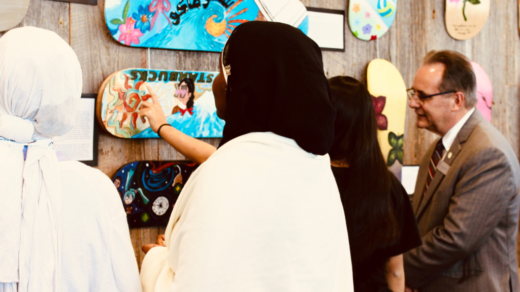 Guests learning about the "Be You" project and looking at the skateboards