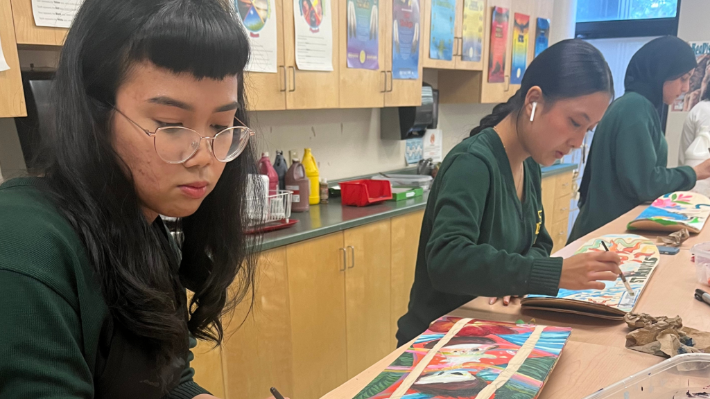 OCSB students painting the skateboard in the school workshop