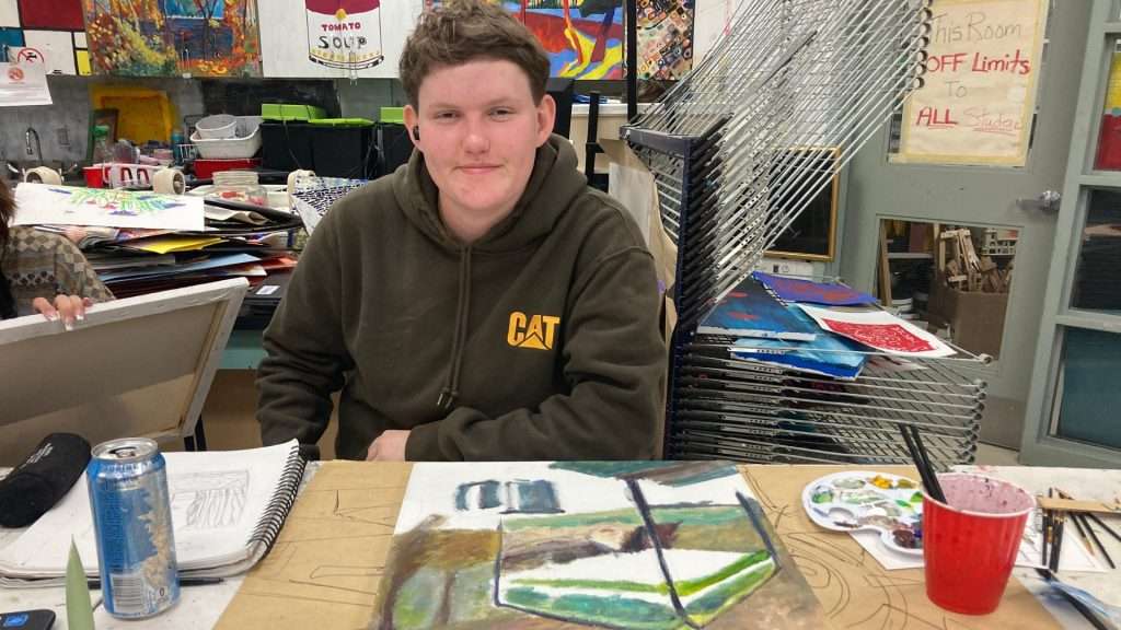 A student works on pieces that reflect shelter spaces and untold stories